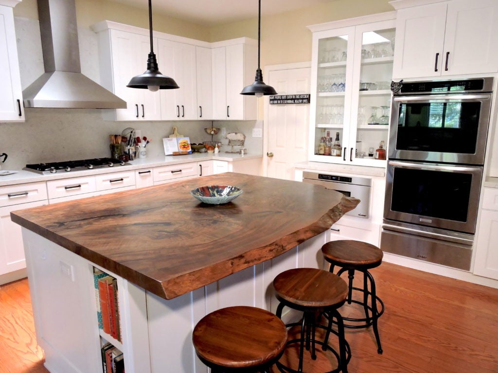 Ramona Kitchen Remodel with Solid Wood Kitchen Island Top, Wood Flooring, White Cabinets, Brushed Aluminum Stove Hood, Brushed Aluminum Oven with Tinted Glass,