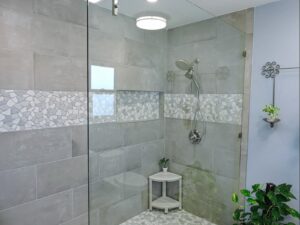 Shower with Glass Sliding Doors Pebbled and Grey Tile