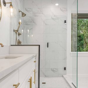 Bathroom Remodeling with Marble Tile Gold Fixtures Frameless Glass Doors