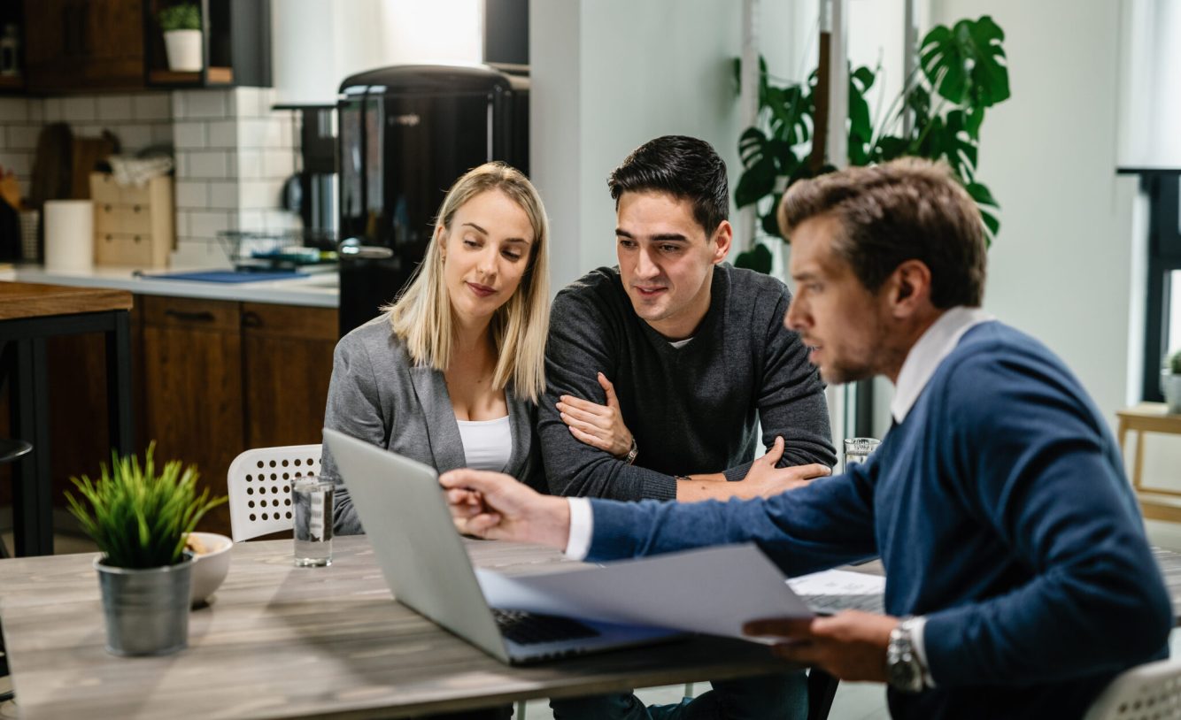 Young couple and real window installer using laptop while going through housing plan on a meeting. - need for build